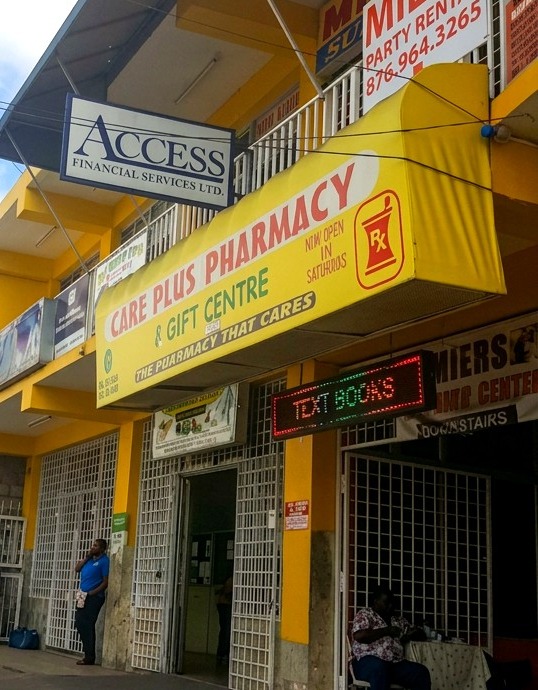 The Care Plus Pharmacy & Gift Centre storefront on the street in Christiana, Manchester